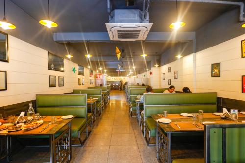 a restaurant with tables and chairs and people sitting at them at Hotel Dolphin International in Varanasi