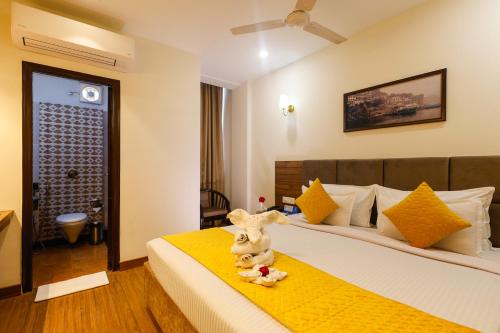 a hotel room with a bed with a stuffed animal on it at Hotel Dolphin International in Varanasi