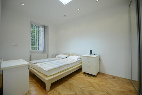 a white bedroom with a bed and a window at Park Lane Central Sarajevo in Sarajevo