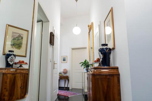a hallway with two mirrors and vases on wooden cabinets at Royal Residence Schönbrunn in Vienna