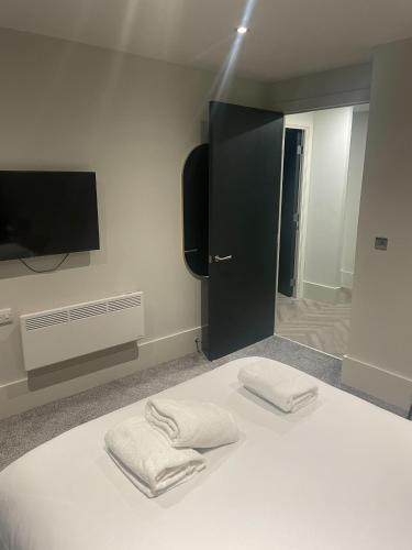 a bedroom with a bed with two towels on it at 1 Bed Apt - Balcony - City View - Great Location in Liverpool