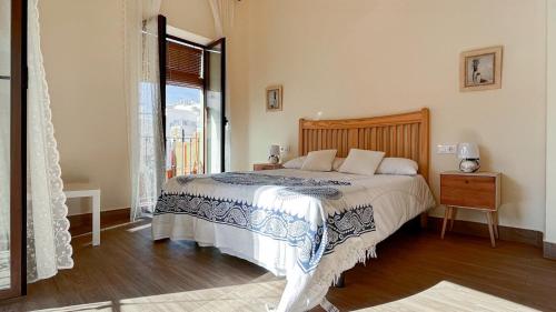 ANTEQUERA SUITES في أنتيكيرا: غرفة نوم بسرير كبير ونافذة