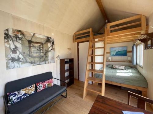 a bedroom with a bunk bed and a couch at Da Silva Surfcamp, Tiny House Luna in Lourinhã