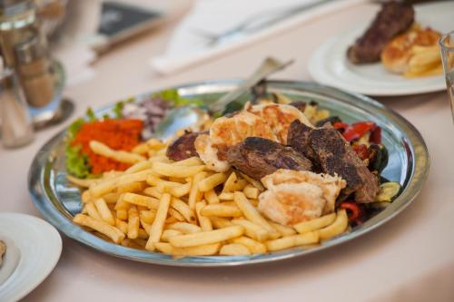 a plate of food with french fries on a table at Hotel Biokovo in Makarska
