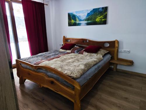 a bedroom with a wooden bed in a room at Chalety Bystrá in Bystrá