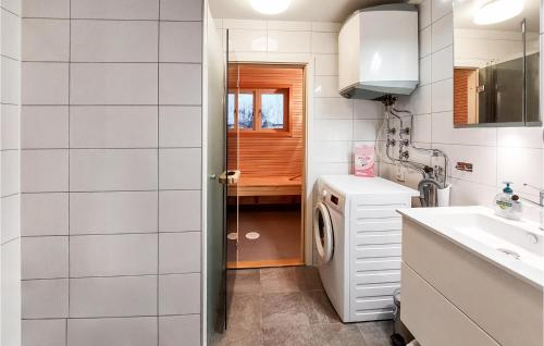 uma pequena cozinha com um lavatório e uma máquina de lavar roupa em 6 Bedroom Stunning Home In Torekov em Torekov