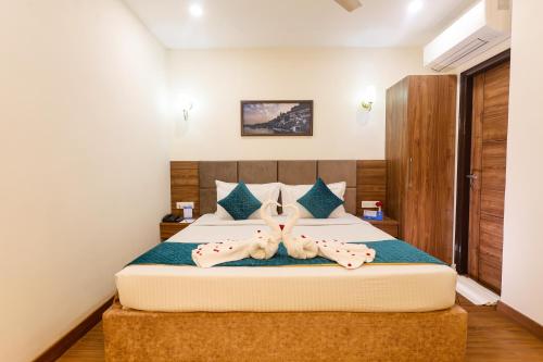 a bedroom with a bed with two towels on it at Hotel Dolphin International in Varanasi