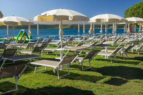 a row of chairs and umbrellas on the grass at Hotel Vile Park in Portorož