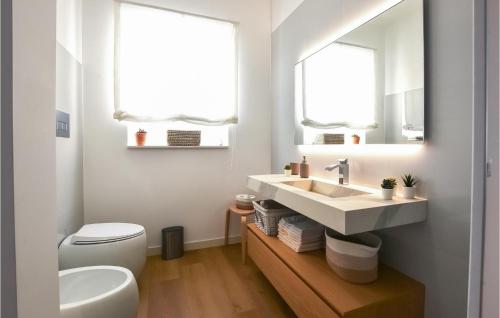 baño con lavabo y aseo y 2 ventanas en Nice Home In Catenanuova With Swimming Pool, en Centuripe