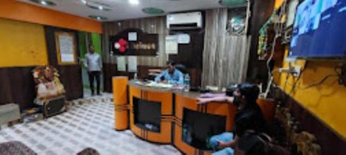 une salle avec des personnes assises dans un bar dans un restaurant dans l'établissement Hotel Delmon,Bhubaneswar, à Bhubaneswar