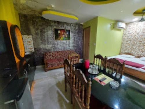 - un salon avec une table et des chaises dans l'établissement Hotel Delmon,Bhubaneswar, à Bhubaneswar