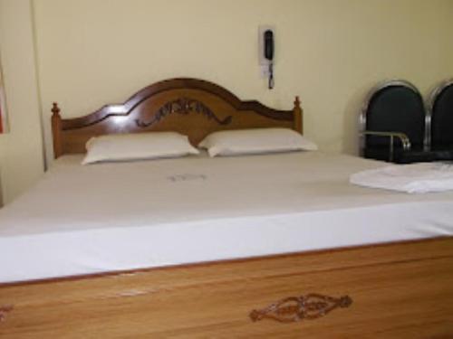 a large white bed with two pillows on it at Hotel Chancellor,Bhubaneswar in Bhubaneshwar