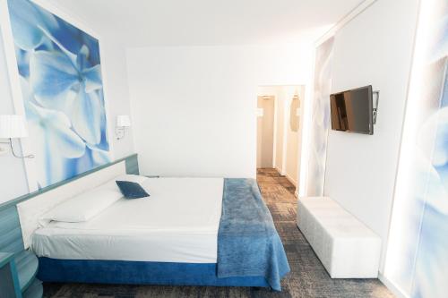 a bedroom with a bed and a tv on a wall at MyContinental Suceava in Suceava
