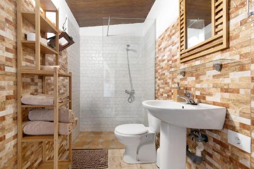 uma casa de banho com um lavatório branco e um WC. em Hogar vacacional Maya em Santa Maria de Guia de Gran Canaria