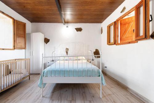 uma cama branca num quarto com um berço em Hogar vacacional Maya em Santa Maria de Guia de Gran Canaria