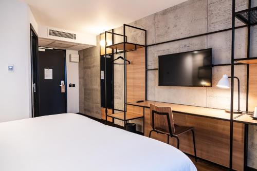 a bedroom with a bed and a desk and a tv at ibis Coleraine Riverside in Coleraine