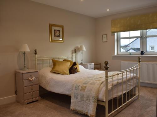 a bedroom with a bed with a dog laying on it at Poppy House in Kirkoswald