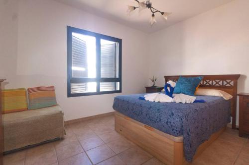 Schlafzimmer mit einem Bett und einem Fenster in der Unterkunft Casa Bianca Caleta De Famara in Famara