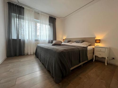 een slaapkamer met een bed en een groot raam bij Ferienwohnung am Bodensee "Zum Salm" in Nußdorf