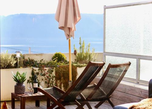 two chairs and an umbrella on a patio at SeaSide in Sipplingen