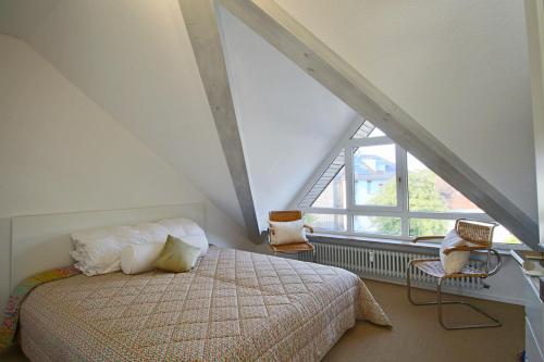 ユーバーリンゲンにあるMaisonette Am Mantelsteigの屋根裏のベッドルーム(ベッド1台、窓付)