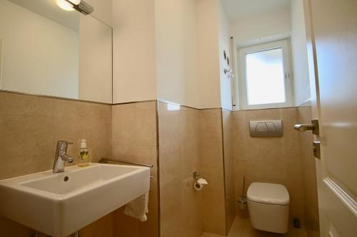 ユーバーリンゲンにあるMaisonette Am Mantelsteigのバスルーム(洗面台、トイレ、鏡付)
