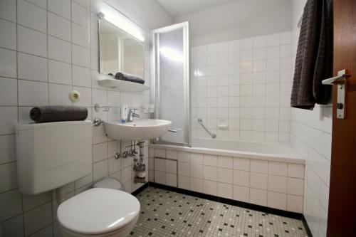 a bathroom with a toilet and a sink and a tub at FeWo Louisa in Sipplingen