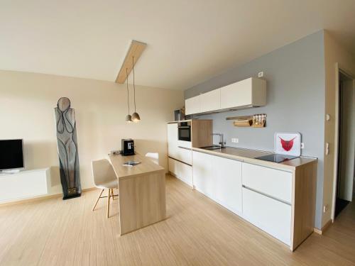 a kitchen with white cabinets and a table at Apartment EigenArt in Owingen