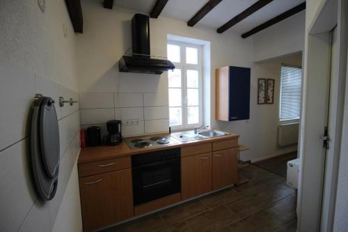 a kitchen with a stove and a sink and a refrigerator at NEU! FeWo Winkeleck in Alsfeld