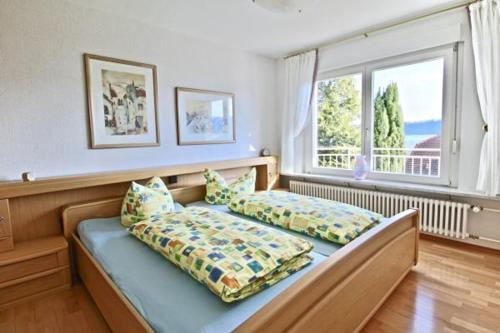 1 dormitorio con 1 cama y 2 almohadas en Seeterrasse mit Seeblick, en Sipplingen