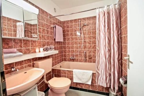 łazienka z umywalką, toaletą i wanną w obiekcie Strandweg w mieście Überlingen