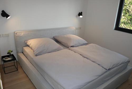 a bed with two pillows on it in a room at seenahe Design-Ferienwohnung Loft Azur in Überlingen