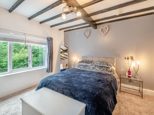 a bedroom with a large bed and a window at Poulter Cottage in Elkesley