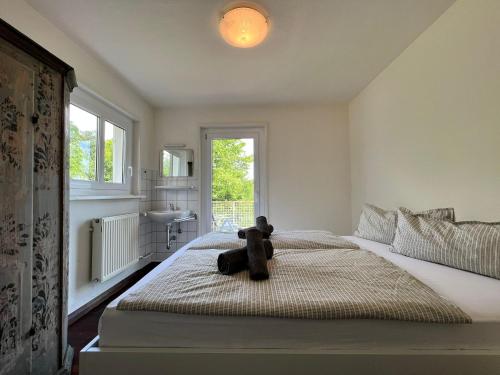 a teddy bear sitting on a bed in a bedroom at Landhaus am See mit privatem Seezugang in Meersburg