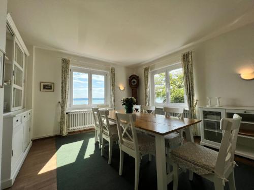 - une salle à manger avec une table et des chaises en bois dans l'établissement Landhaus am See mit privatem Seezugang, à Meersburg