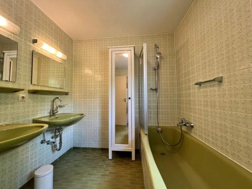 uma casa de banho com uma banheira verde e um lavatório em Landhaus am See mit privatem Seezugang em Meersburg