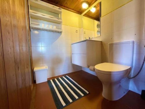 La salle de bains est pourvue de toilettes blanches. dans l'établissement Da Silva Surfcamp- Terrassenzimmer mit Frühstück, à Lourinhã