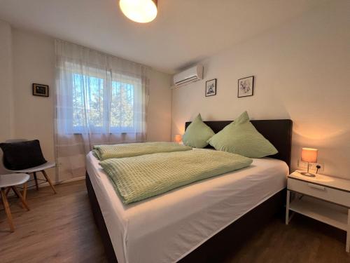 a bedroom with a large bed and a window at Ferienwohnung am Tobelbach in Überlingen