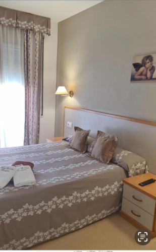 a bedroom with a bed with a blue comforter at Hotel Cosmos Tarragona in Tarragona