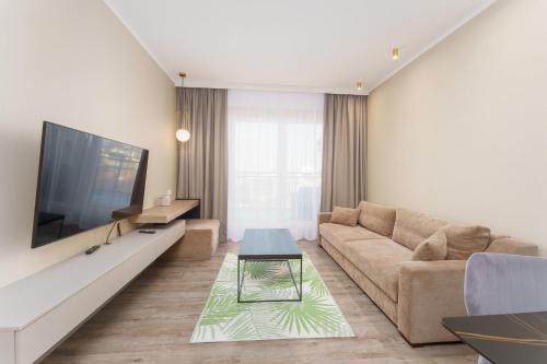 Miedzyzdroje SEASIDE Apartments Bel Mare by Renters في مينززدرويه: غرفة معيشة مع أريكة وتلفزيون