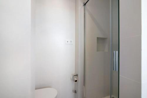 La salle de bains est pourvue de toilettes et d'une douche en verre. dans l'établissement Casa Alameda, à Faro