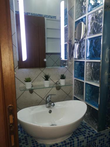 a bathroom with a white sink and a mirror at Makis Nest Apart-Hotel in Vourvourou