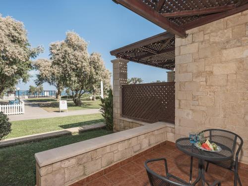 a patio with a table and chairs and a fence at Caldera Creta Paradise in Plataniás