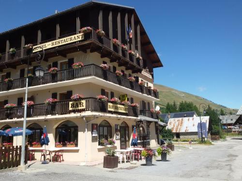 a building with a balcony and tables and chairs at Le Relais du Galibier in Valloire