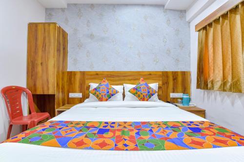 een slaapkamer met een groot bed en een kleurrijk dekbed bij FabHotel Star in Ahmedabad