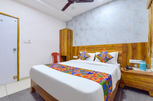 a bedroom with a large bed with a wooden headboard at FabHotel Star in Ahmedabad