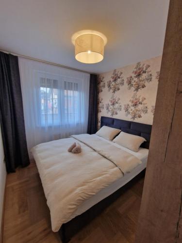 a bedroom with a bed with a stuffed animal on it at Moments Banja Luka in Banja Luka