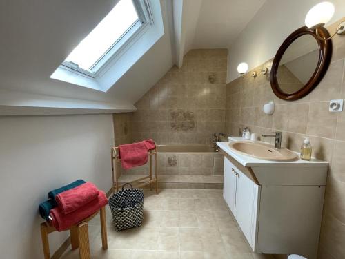 a bathroom with a sink and a mirror and a tub at Chez evelyne et titou in Bordères
