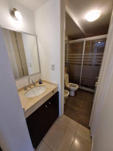 bagno con lavandino, servizi igienici e specchio di HERMOSO - CONFORT con Balcón en Gral Paz a Córdoba