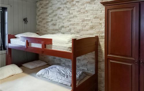 a bedroom with a bunk bed and a brick wall at Stunning Apartment In Noresund With Kitchen in Noresund